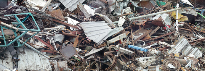 Panoramic view of pile of scrap rusty metal waste on recycling yard. Disposal and secondary metal...
