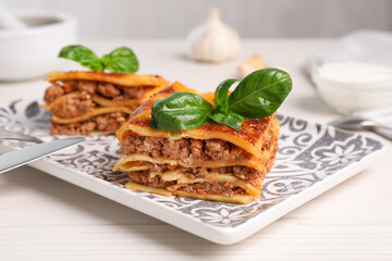 Delicious lasagna served on white table, closeup