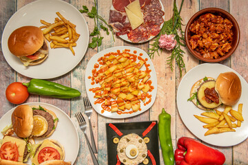 Fototapeta na wymiar top view of plates with hamburgers and typical tapas from Spain with some peppers and tomatoes