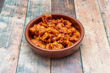 Spanish tapa of marinated pork ear inside clay pan