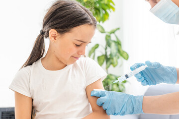 nurse giving vaccination injection to little girl patient