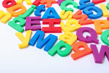 Many colorful magnetic letters on white background