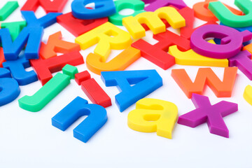 Many colorful magnetic letters on white background
