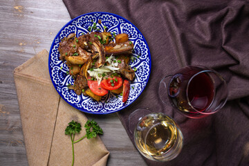 onions and tomatoes on a blue plate with wine