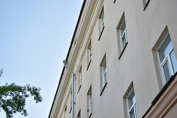 The facade of the old yellow building in the evening with trees