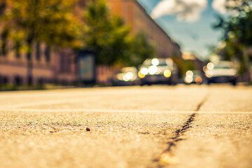 Clear day in the big city, the cars goes down the street. View from the level of asphalt