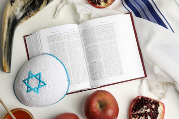 Flat lay composition with Rosh Hashanah holiday symbols on white wooden table