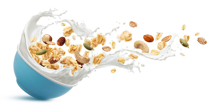 Falling muesli, oat granola with milk splashing isolated on white background