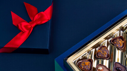 Chocolates set in gold box with a red bow