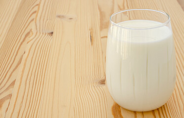 One glass of milk on a wooden background