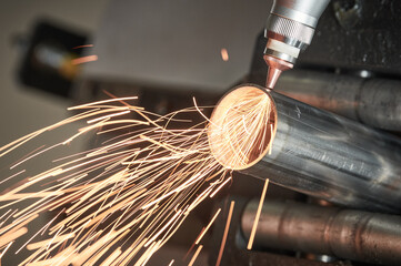 Fiber laser tube cutting machine. metal pipe cutting with sparks - obrazy, fototapety, plakaty