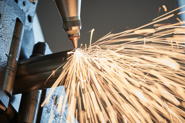 Fiber laser tube cutting machine. metal pipe cutting with sparks