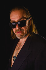 Obraz premium Portrait of a man in a jacket and sunglasses, rock.