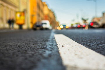 Clear day in the big city, the lights of the approaching cars. View of the road at the level of the dividing line