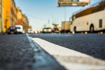 Clear day in the big city, the lights of the approaching cars. View of the road at the level of the dividing line