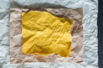 crumpled paper background - layered yoke yellow, beige, and off white winkled and flattened sheets...