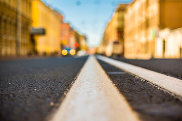 Clear day in the big city, empty city street and headlights moving car. View of the road at the...