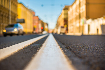 Clear day in the big city, car traveling on an empty city street. View of the road at the level of the dividing line