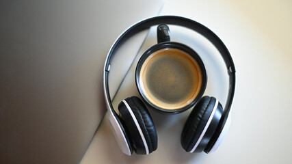 Top view shot of Coffee mug with laptop and headphone on placed on a table in a cafe,Coffee mug place in headphone.