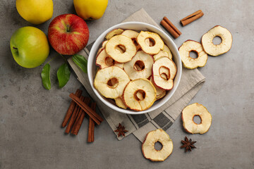 Delicious apple chips, fresh fruits, anise and cinnamon on grey table, flat lay
