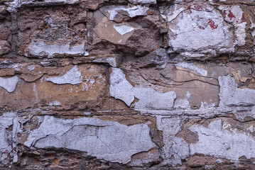 Old dirty brick wall. Paint is falling off.