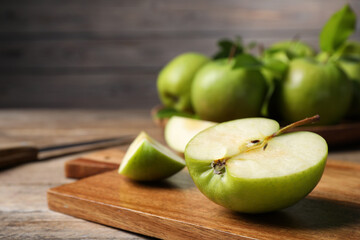 Cut fresh green apple on wooden table, closeup