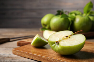 Cut fresh green apple on wooden table, closeup