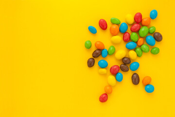colorful candies or nuts splitted on yellow background