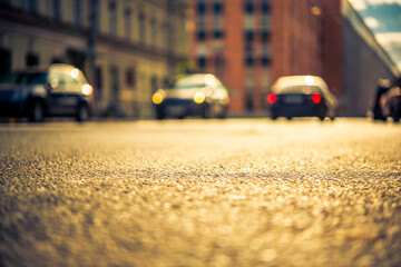 Autumn in the city, cars drive on the road. View from the level of asphalt