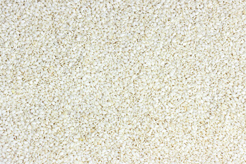 Top view of white sesame seeds texture as a food background.