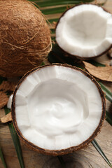 Ripe coconut with cream on wooden table, above view