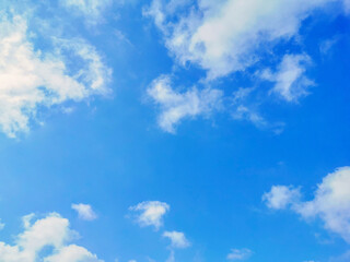 Obraz premium Blue sky with fluffy white clouds. Beautiful sky in the morning. Copy space is in the middle of photo. The concept of new life beginning, freedom of life, positive energy and peaceful mind. 