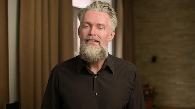 gray-haired bearded adult man listens attentively to something, communicating via video communication, view from the person of the interlocutor