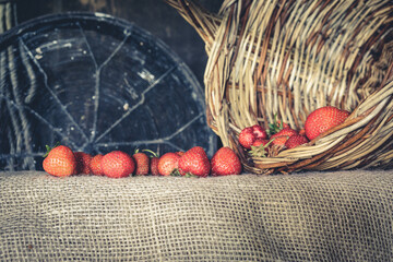 Strawberries in a basket on a wooden background