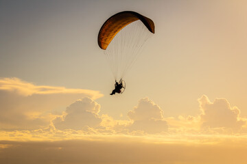 Paraglider fly in the sky above the sea.

