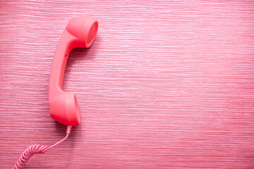 Phone call with pink phone - connection concept on vibrant background, contact us