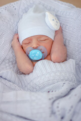 Sleeping newborn baby boy with pacifier. Babyface close-up.