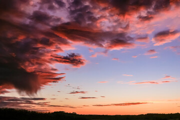 Fototapeta na wymiar Vibrant sunset clouds with a rain shower.
