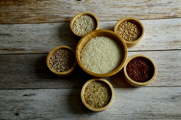 Brown Glutinious Rice, Red Jasmine Rice, Oat Rice, Barley, Millet Rice, Brown Wheat in wooden bowl on wooden table background.