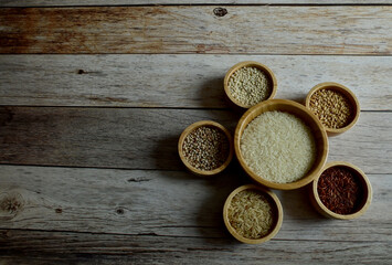 Brown Glutinious Rice, Red Jasmine Rice, Oat Rice, Barley, Millet Rice, Brown Wheat in wooden bowl on wooden table background.