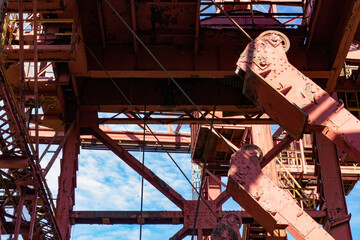 View through the exterior of an industrial facility to blue sky and clouds beyond, sunny day, horizontal aspect