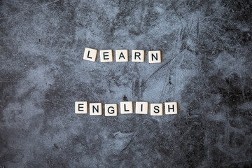 Fototapeta na wymiar learn english word written on grey marble background. learn english text on table, concept. Horizontal