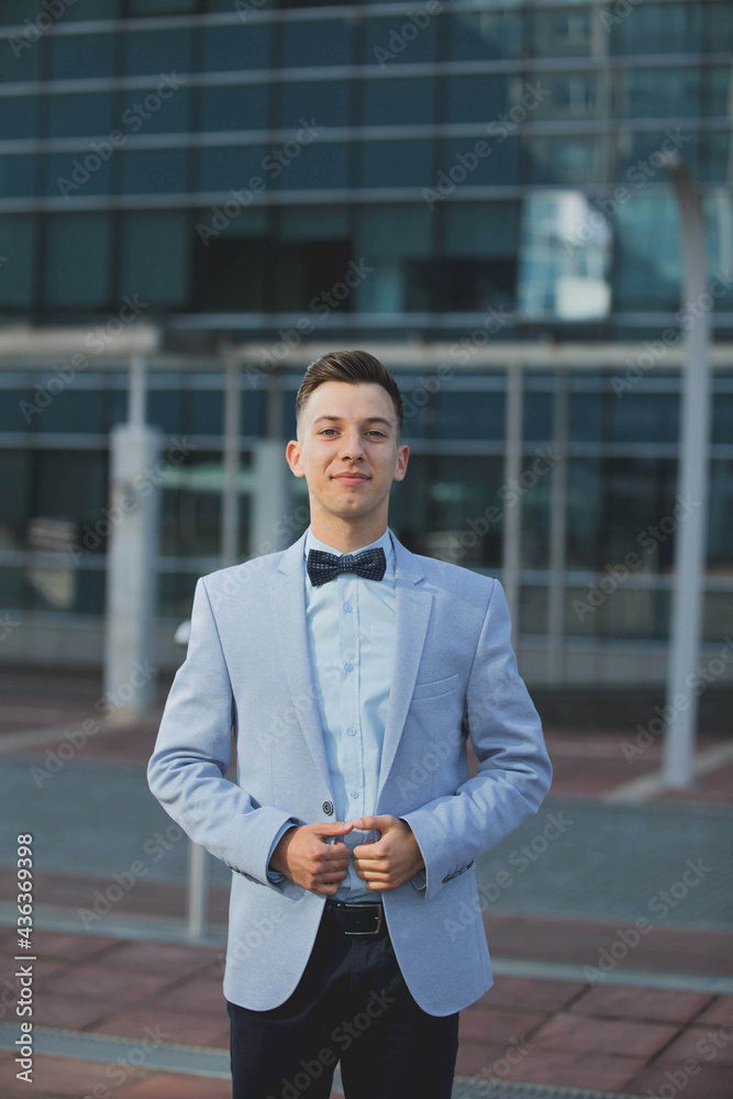 Wall mural Vertical shot of a white Caucasian man wearing a classic blue suit and posing for a picture