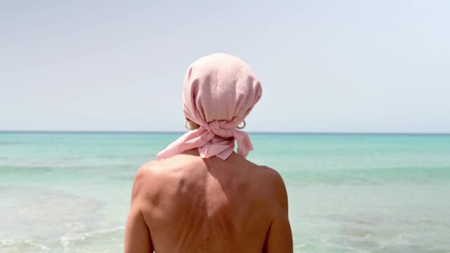 Woman with pink headscarf, has cancer