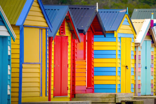 A row of colourful multi-coloured wooden beach huts at Brighton Beach, Melbourne, Victoria State, Australia	