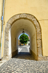 A narrow street between the old houses of Montefredane, a medieval village in the province of...