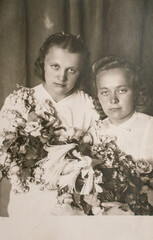 Latvia - CIRCA 1930s: Close up portrait of two woman with flowers in studio. Vintage Art Deco era...