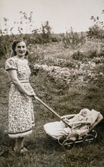 Germany - CIRCA 1930s: Portrait of mother and baby in carriage. Young female and baby in stroller...