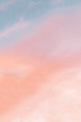 Vertical background formed by a bright pastel authentic sky during sunset. Pink, peach, blue blur...