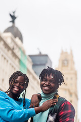 Black couple in love, in the city. Looking at camera smiling.